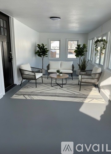 A living room with a rug and chairs.