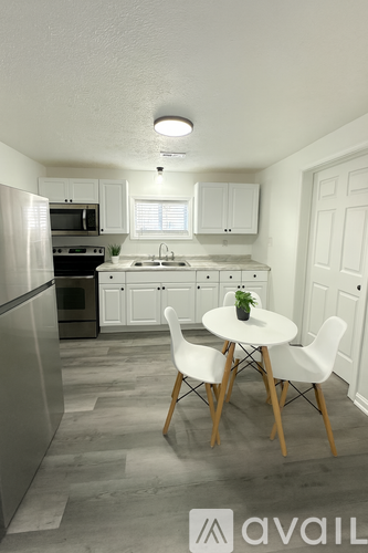 A kitchen with a table and chairs.