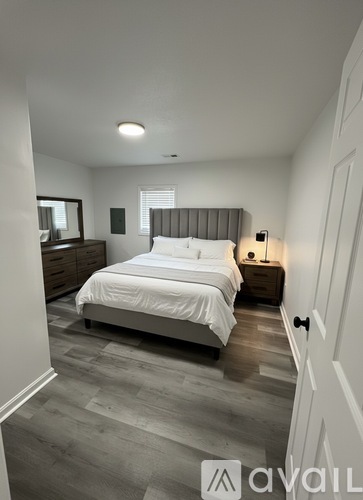 A bedroom with a bed, nightstand, and lamp.