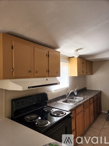A kitchen with wooden cabinets and a black stove top oven.
