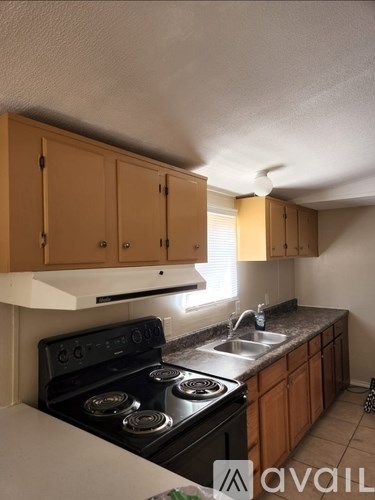 A kitchen with wooden cabinets and a black stove top oven.