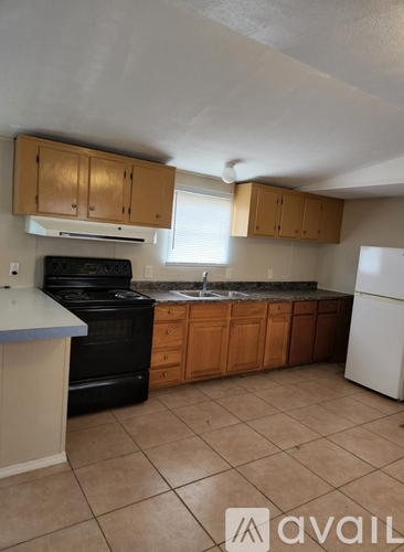 A kitchen with a black oven and a white fridge.