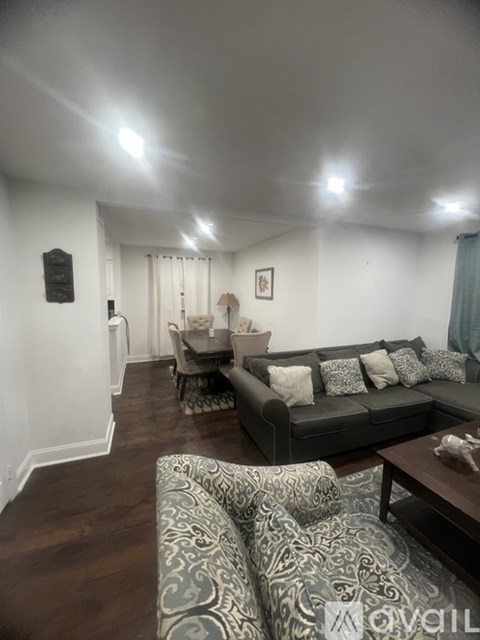 A living room with a grey couch and a patterned sofa.