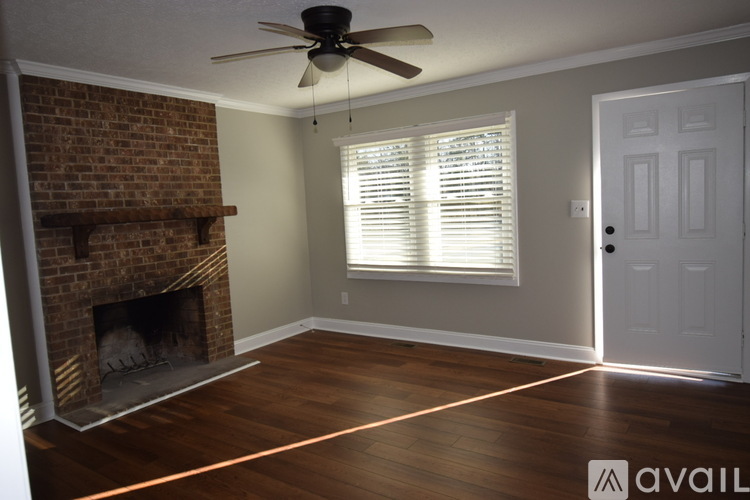 A room with a fireplace and a ceiling fan.