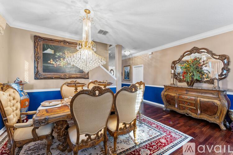 A dining room with a chandelier, a table with chairs, and a sideboard.