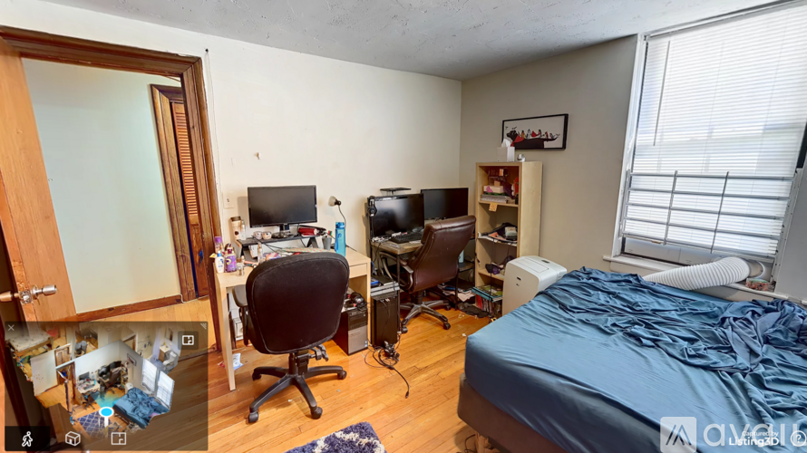 A bedroom with a bed, desk, and chair.