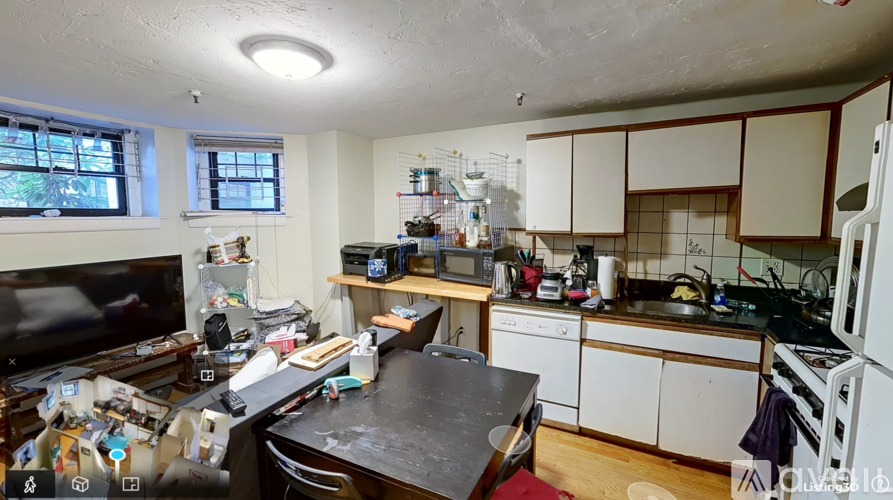 A kitchen with a black countertop and white cabinets.
