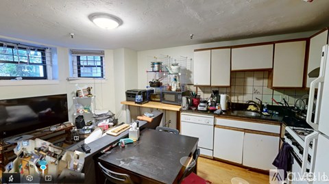 A kitchen with a black countertop and white cabinets.