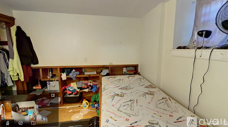 A small bedroom with a bed, desk, and cluttered space.