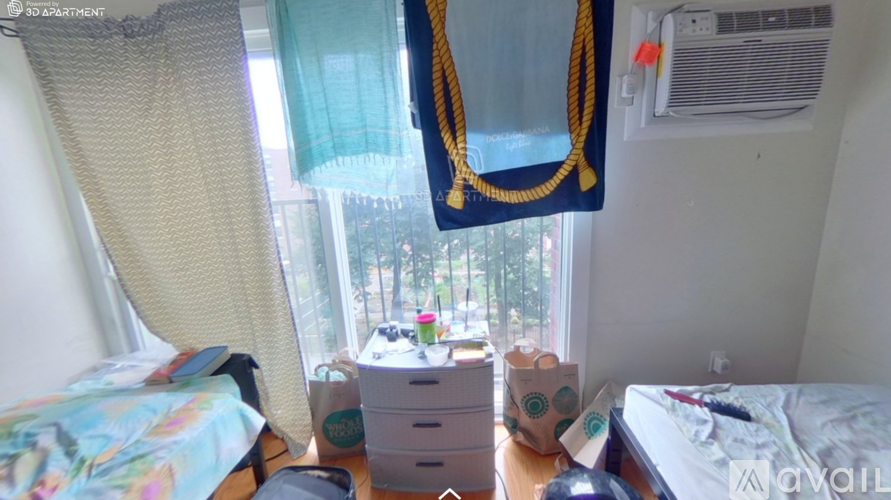 A bedroom with a bed, a dresser, and a window with curtains.