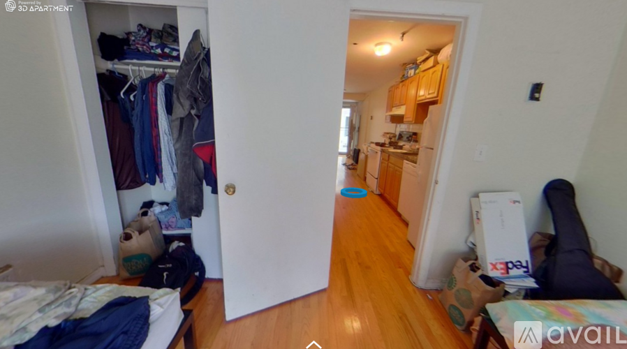 A room with a bed, a wardrobe, and a kitchen area.