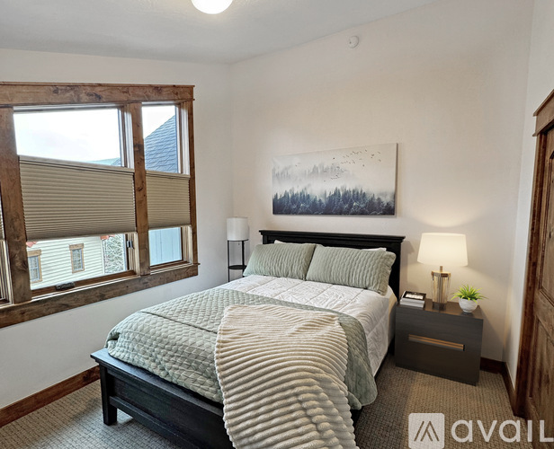 A bedroom with a large bed and a painting on the wall.
