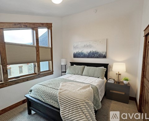 A bedroom with a large bed and a painting on the wall.