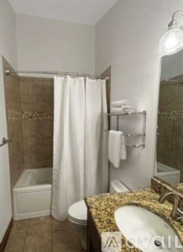A bathroom with a toilet, sink, and shower.