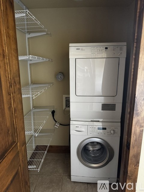 A white dryer and washer are in a small laundry room.