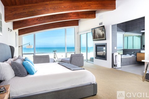 A bedroom with a large bed and a view of the ocean.