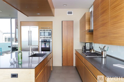 A modern kitchen with wooden cabinets and a black countertop.