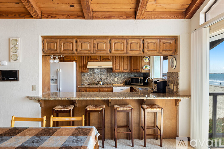 A kitchen with wooden cabinets and a refrigerator.