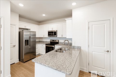 A kitchen with a granite countertop and stainless steel appliances.