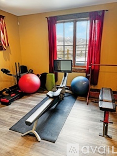 A gym room with pilates equipment and a large window.