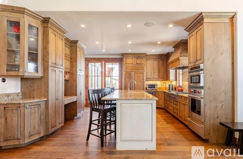 A kitchen with wooden cabinets and a white island.