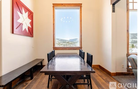 A dining room with a wooden table and chairs.