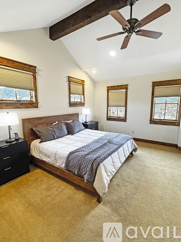 A bedroom with a bed, nightstand, and a ceiling fan.