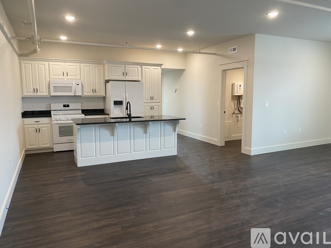 A kitchen with white cabinets and a white refrigerator.