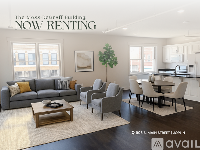 A living room with a grey couch, a coffee table, and a dining table with chairs.