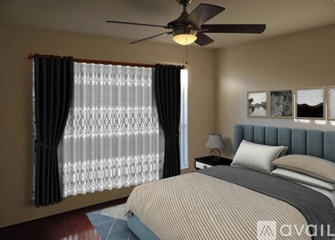 A bedroom with a bed, a ceiling fan, and a window with curtains.