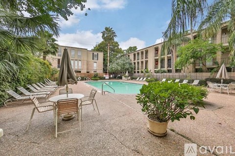 A poolside area with chairs and a table.