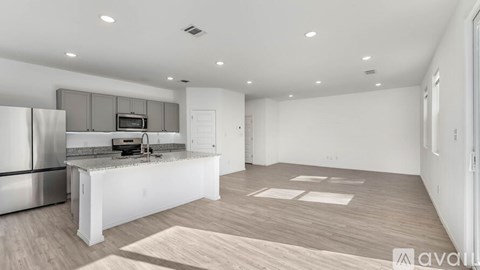 A kitchen with a refrigerator, microwave, and sink.