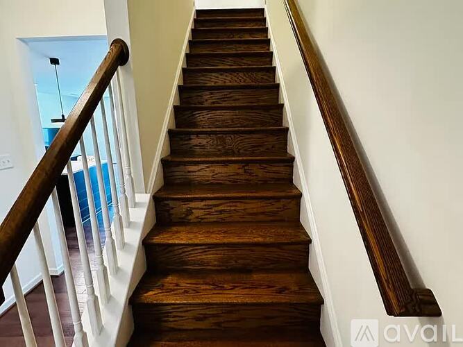 A long flight of wooden stairs with white balusters.