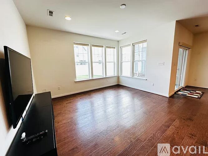 A living room with a flat screen TV mounted on the wall.