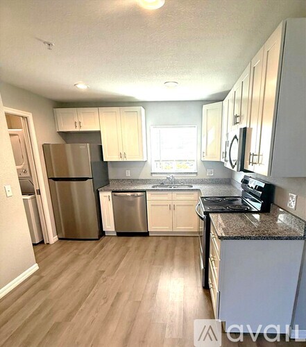 A kitchen with wooden floors and stainless steel appliances.
