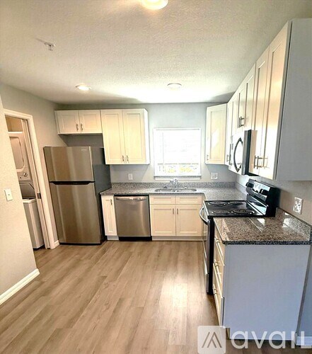 A kitchen with wooden floors and stainless steel appliances.