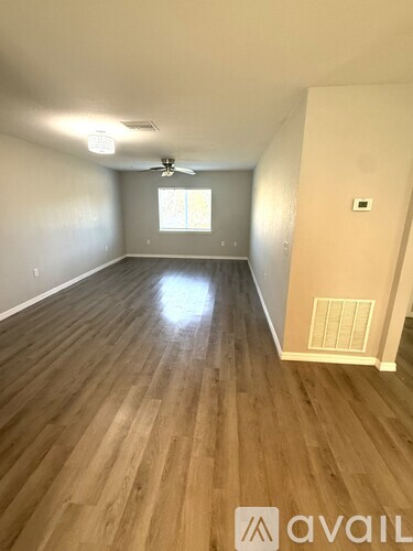 A room with wooden flooring and a ceiling fan.