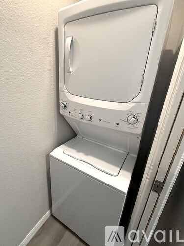 A white washing machine is installed in a small room.