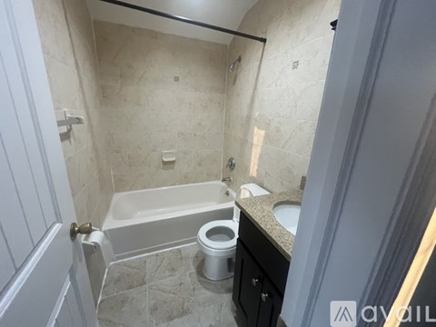 A bathroom with a bathtub, toilet, and sink.