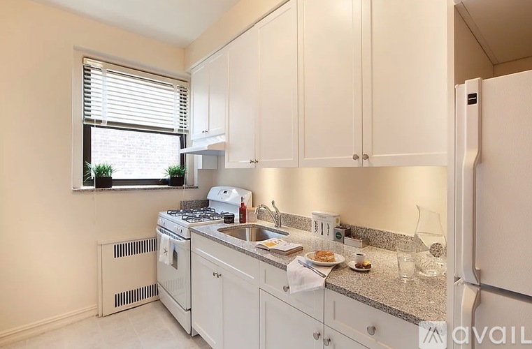 A kitchen with white cabinets and appliances.