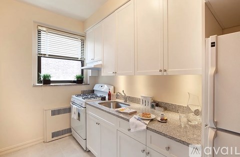 A kitchen with white cabinets and appliances.