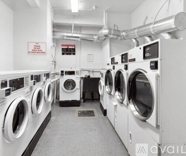 A row of industrial washing machines in a laundry facility.