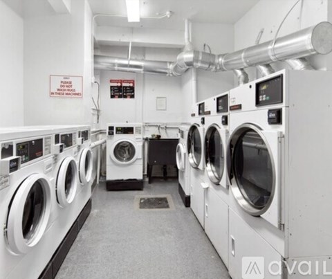 A row of industrial washing machines in a laundry facility.