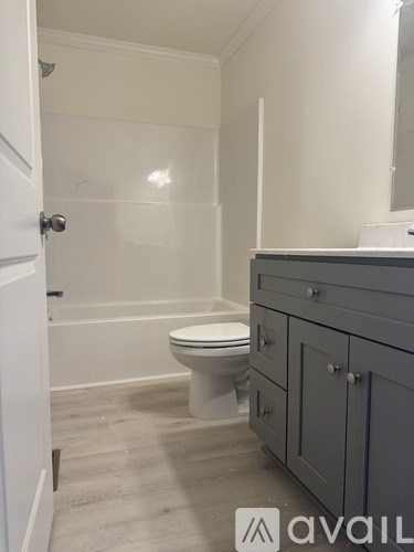 A bathroom with a toilet, sink, and cabinet.