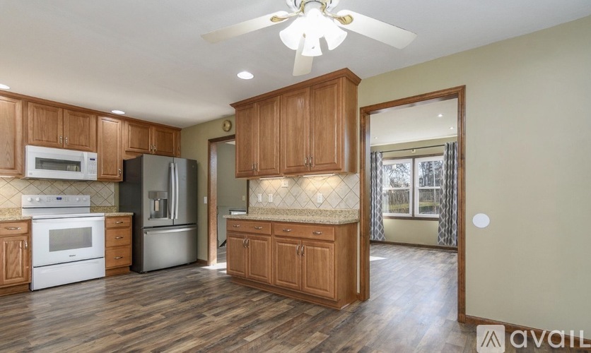 A kitchen with wooden cabinets and a stainless steel refrigerator.