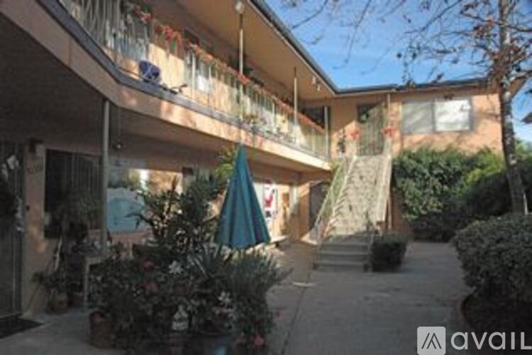 A balcony with a blue umbrella is on the left side of the building.