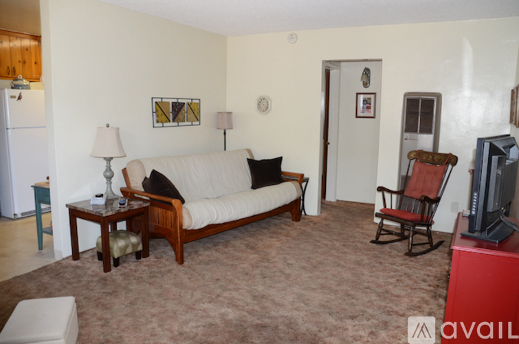 A living room with a couch, chair, and television.