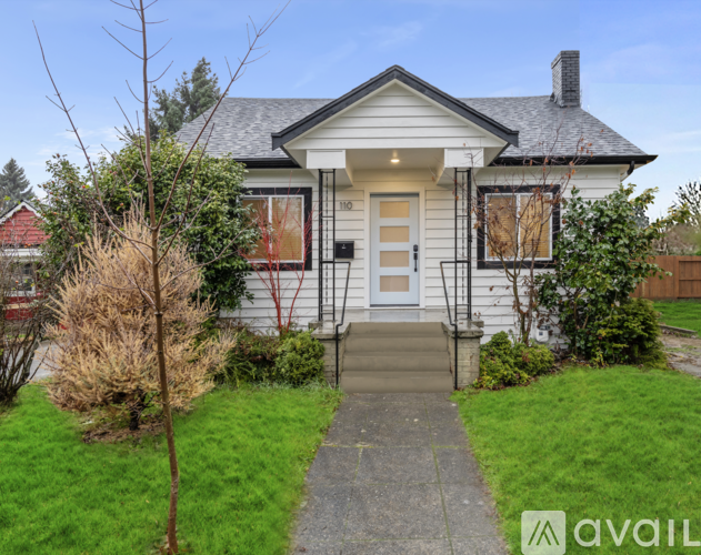 A house with a front yard and a tree.