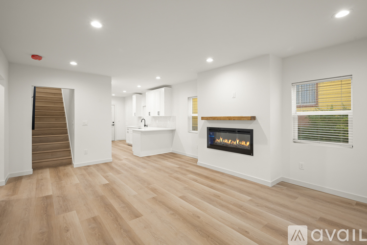 A spacious living room with a fireplace and wooden flooring.