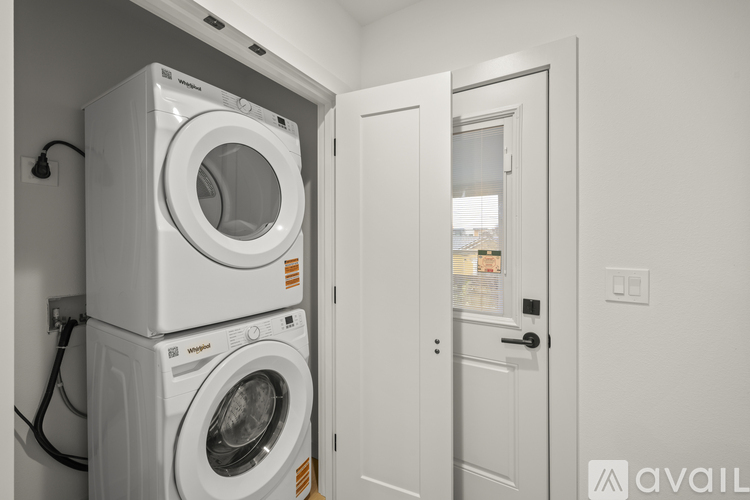 A stack of two Whirlpool washing machines in a laundry room.